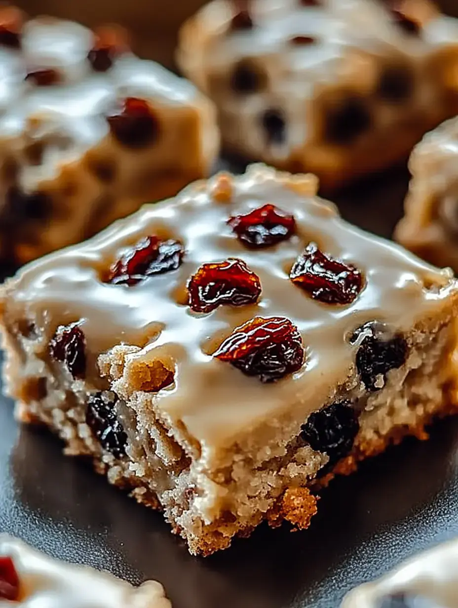 Un gros plan d'un carré de dessert moelleux recouvert de glaçage et garni de fruits secs.